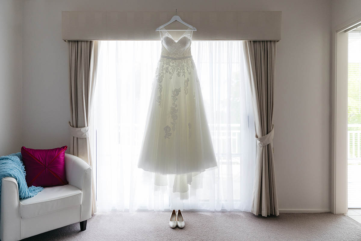 Wedding photos of dress hanging in window